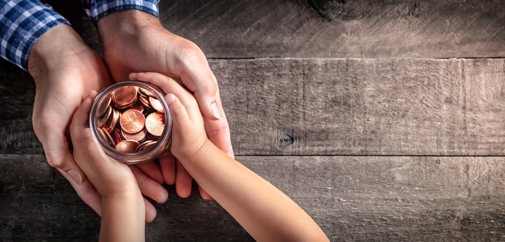 Father and son holding a jar of life savings for his college.